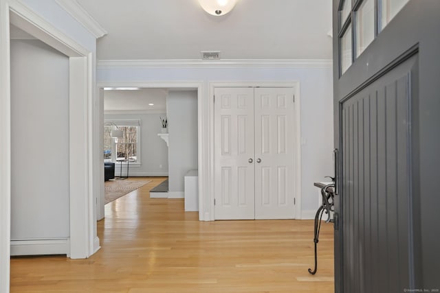 entryway featuring crown molding, a baseboard radiator, and wood-type flooring