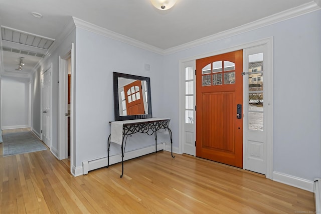 entrance foyer with a baseboard heating unit, ornamental molding, and light hardwood / wood-style floors