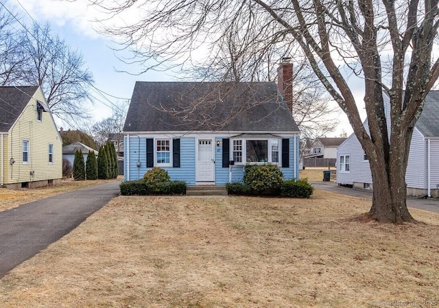 cape cod home with a front yard