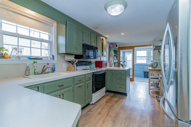 kitchen featuring sink, stainless steel fridge, white range with electric stovetop, and green cabinets