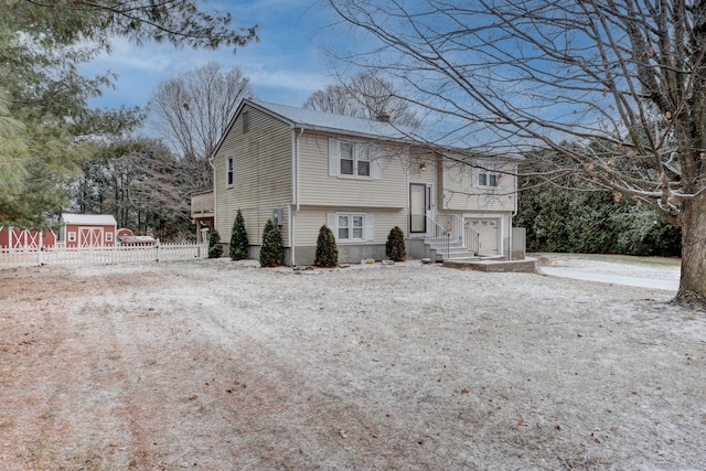 view of front of home featuring a storage unit and a garage