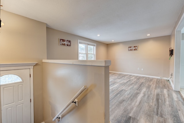 entryway with light hardwood / wood-style floors and a textured ceiling