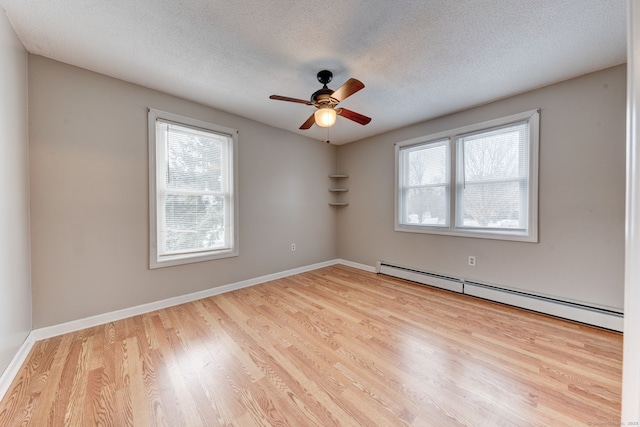 spare room featuring a textured ceiling, light hardwood / wood-style flooring, a baseboard heating unit, and ceiling fan