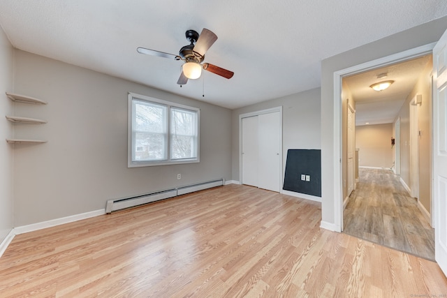 unfurnished bedroom with ceiling fan, baseboard heating, light hardwood / wood-style flooring, and a closet