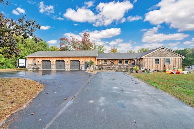 ranch-style house featuring a front yard and a garage