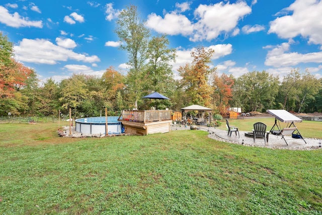 view of yard with a swimming pool side deck and a gazebo