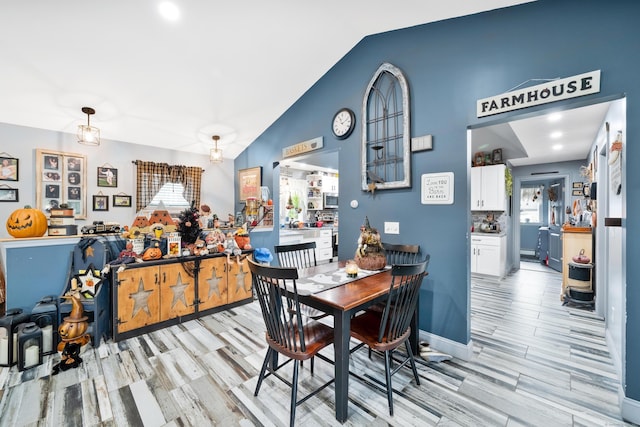 dining space featuring light hardwood / wood-style floors and lofted ceiling