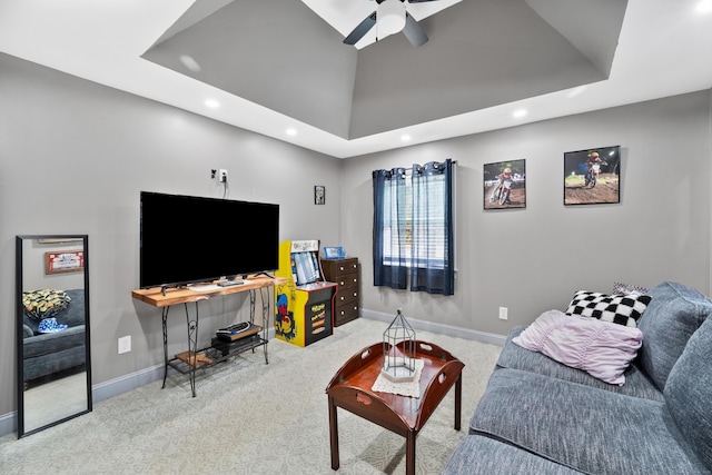 carpeted living room with a tray ceiling and ceiling fan