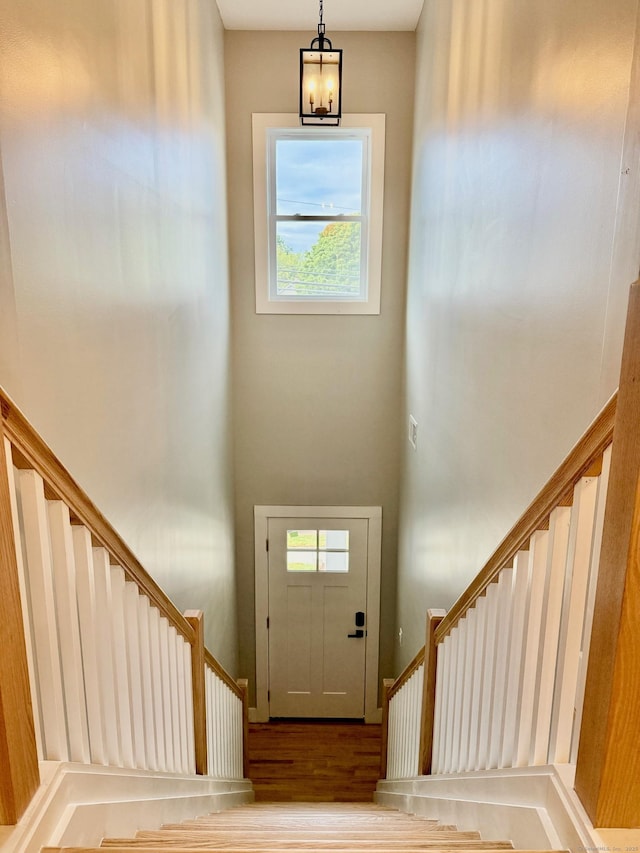 foyer featuring hardwood / wood-style flooring, an inviting chandelier, and a wealth of natural light