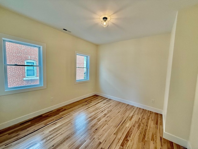 unfurnished room featuring a wealth of natural light and light hardwood / wood-style floors