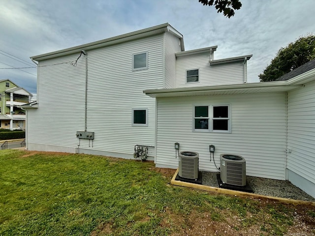 back of house featuring central AC and a lawn