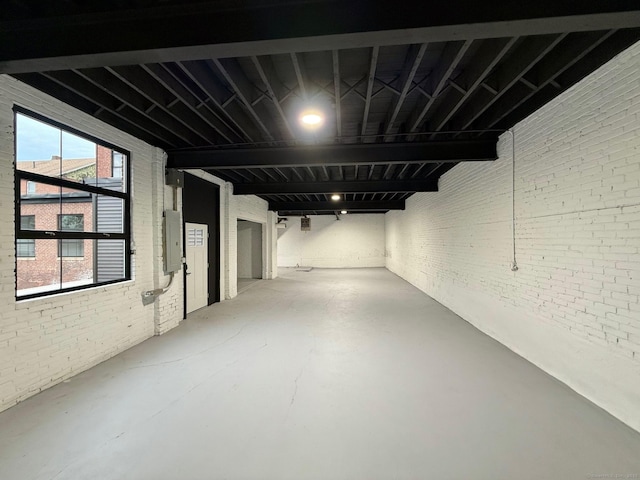 basement with electric panel and brick wall