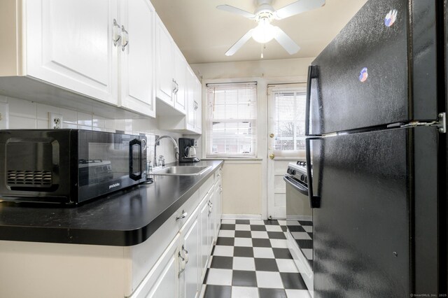 kitchen featuring black refrigerator, decorative backsplash, white cabinetry, ceiling fan, and sink