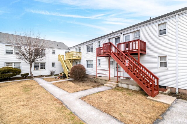 view of front facade featuring a front lawn and a wooden deck