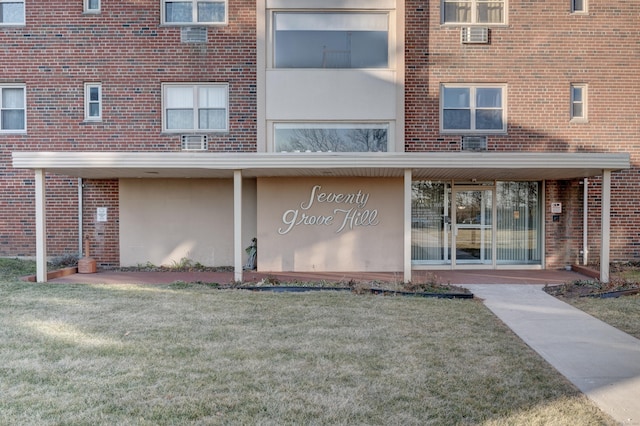 entrance to property with a lawn