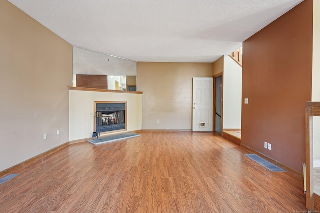 unfurnished living room with a textured ceiling and hardwood / wood-style floors