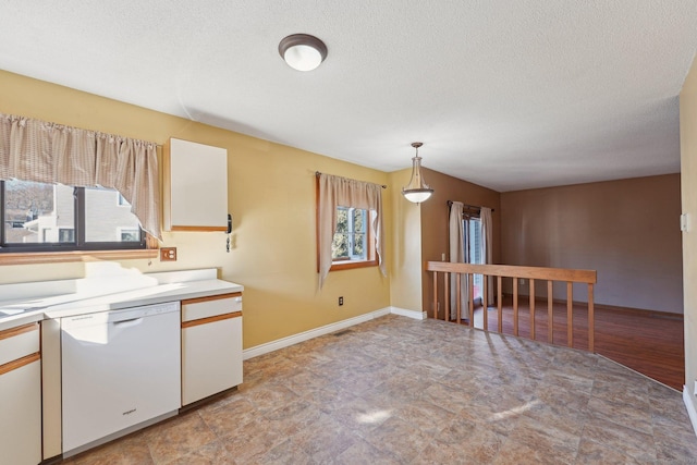 kitchen with decorative light fixtures, a textured ceiling, white dishwasher, and white cabinetry