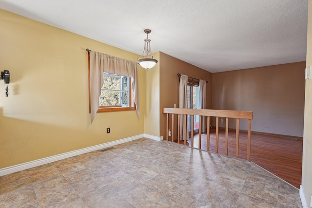 unfurnished room with a textured ceiling