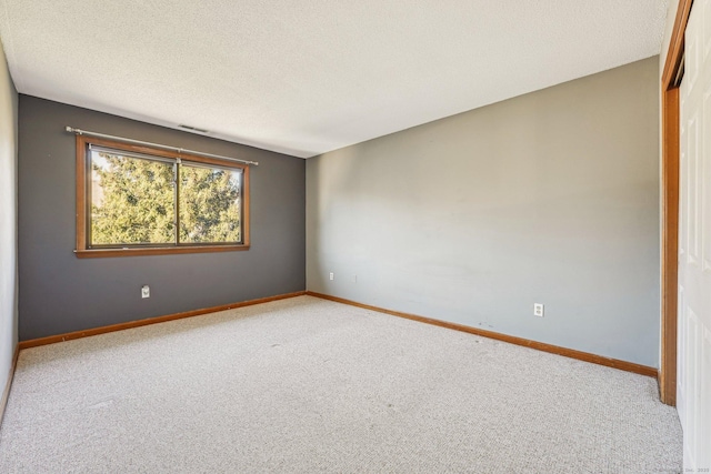 unfurnished room featuring a textured ceiling and carpet