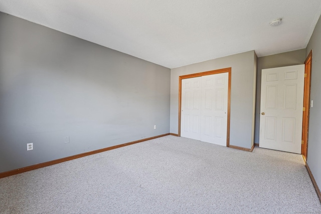 unfurnished bedroom with a closet and light carpet