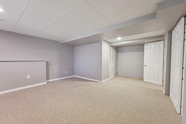 basement with light carpet and a drop ceiling