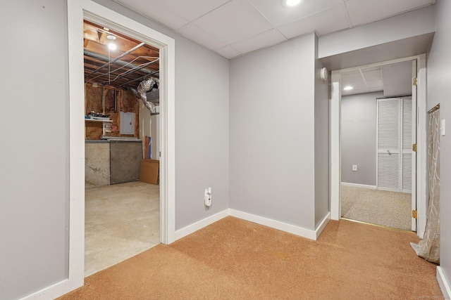 basement with electric panel and light colored carpet