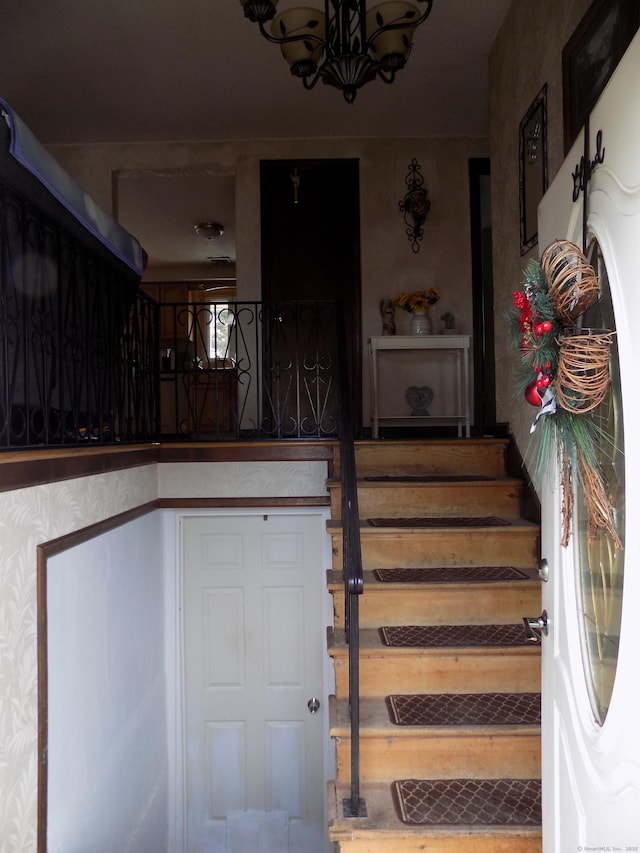 stairs featuring an inviting chandelier