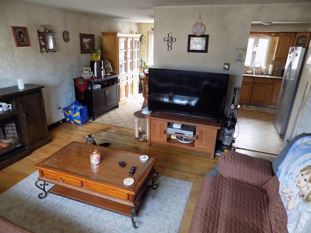 living room with light wood-type flooring and sink