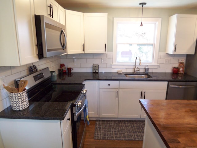 kitchen featuring white cabinetry, sink, stainless steel appliances, and wood counters