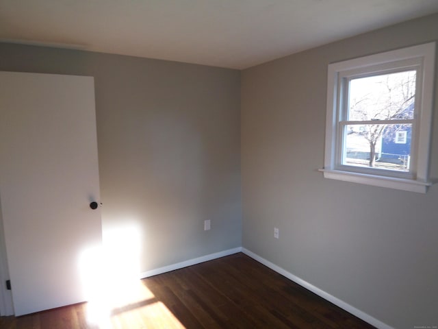 spare room featuring dark wood-type flooring