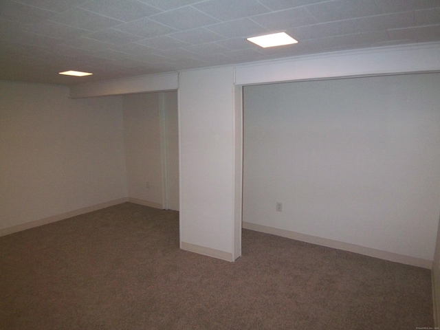 basement featuring a paneled ceiling and carpet