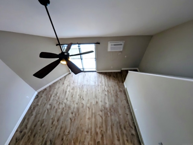 unfurnished living room with an AC wall unit, dark hardwood / wood-style floors, and ceiling fan