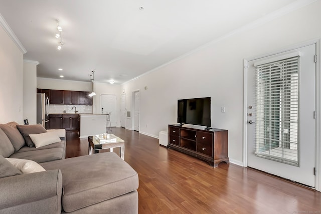 living room with dark wood-type flooring, baseboards, and ornamental molding