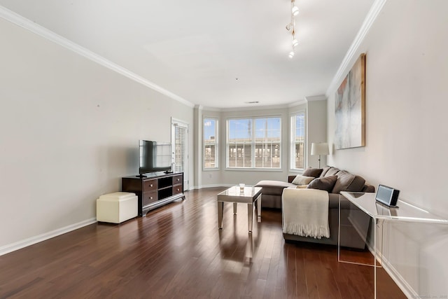 living room featuring dark wood-style floors, track lighting, baseboards, and ornamental molding