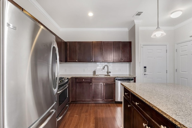 kitchen with dark wood-style floors, visible vents, a sink, decorative backsplash, and appliances with stainless steel finishes