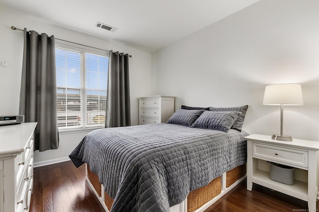 bedroom featuring dark wood-style floors, visible vents, and baseboards