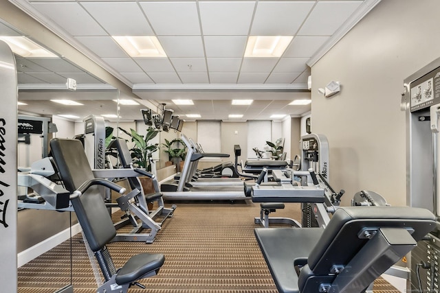 exercise room with carpet flooring, a paneled ceiling, and baseboards