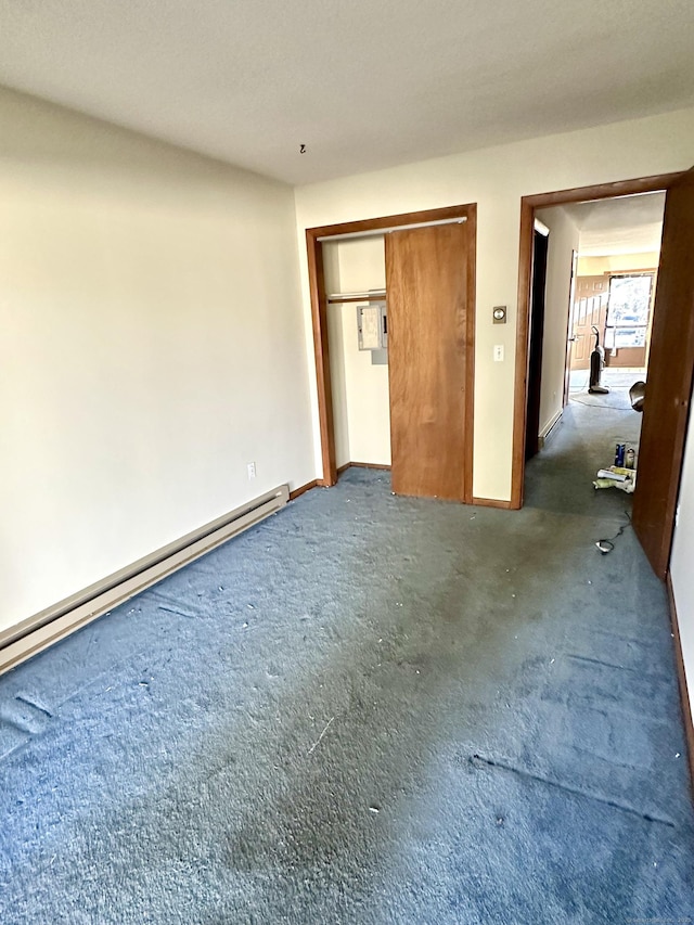 unfurnished bedroom with a closet and a baseboard heating unit