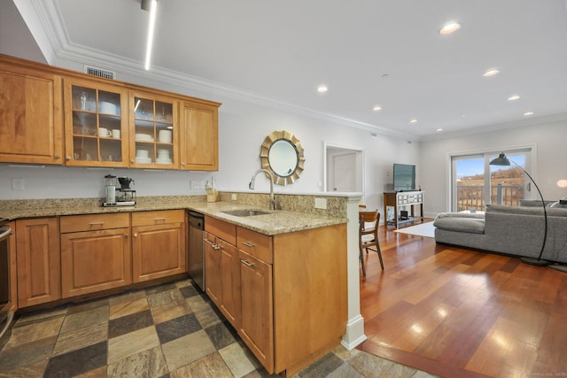 kitchen featuring a peninsula, brown cabinets, and a sink