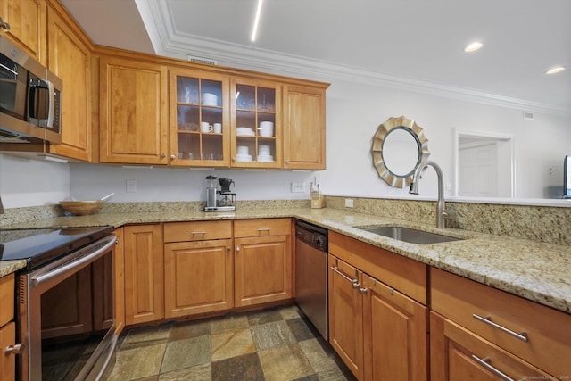 kitchen featuring crown molding, appliances with stainless steel finishes, light stone counters, and a sink