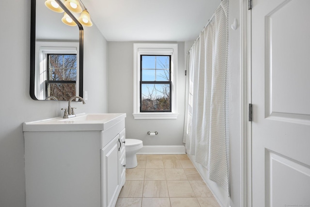 bathroom with toilet, tile patterned flooring, baseboards, and vanity