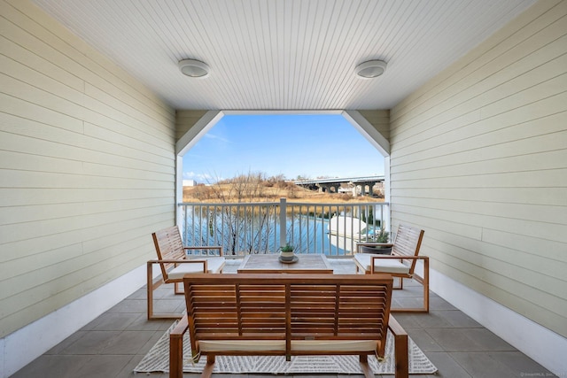 balcony featuring outdoor dining area and a water view