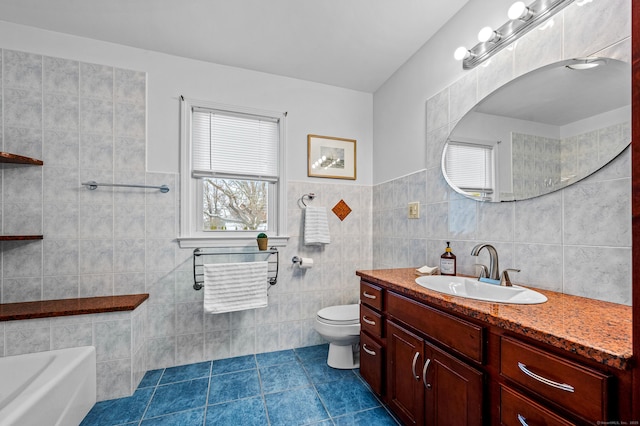 bathroom with toilet, tile walls, vanity, a tub, and tile patterned flooring