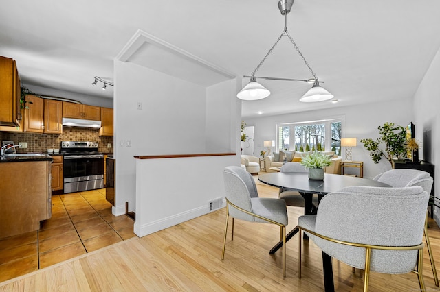 dining area featuring sink and light hardwood / wood-style floors