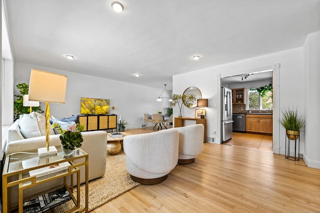 living room with sink and light wood-type flooring