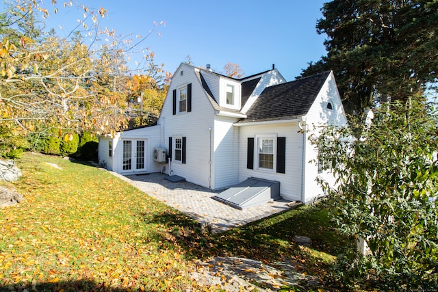 rear view of house featuring a yard, a patio area, and french doors