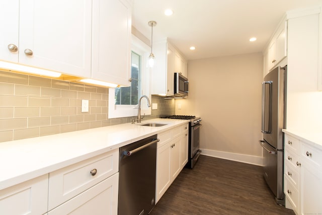 kitchen featuring pendant lighting, white cabinetry, sink, decorative backsplash, and stainless steel appliances