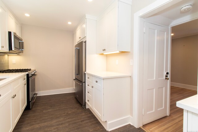 kitchen with white cabinetry, dark wood-type flooring, and stainless steel appliances