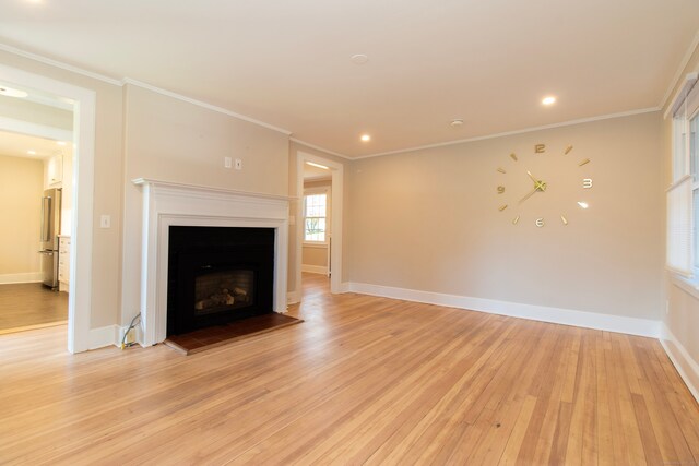 unfurnished living room with crown molding and light wood-type flooring