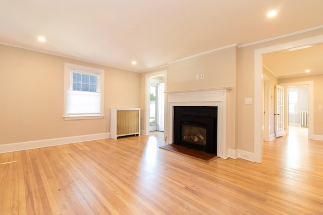 unfurnished living room with ornamental molding, radiator heating unit, and light hardwood / wood-style floors